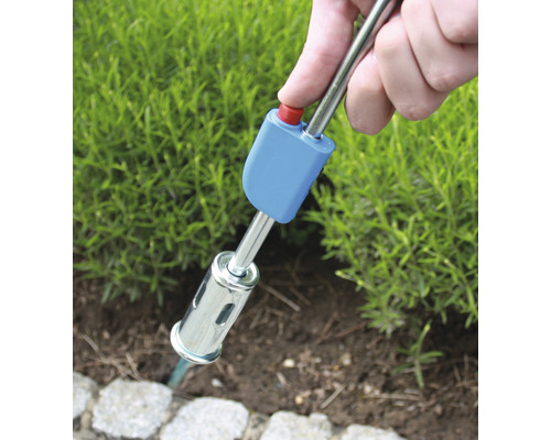 Désherbeur thermique en cours d''utilisation pour éliminer les mauvaises herbes dans le jardin.