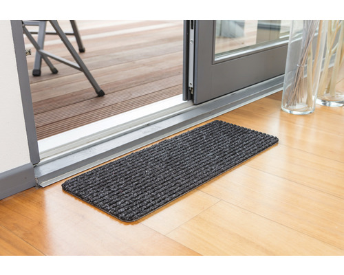 Schmutzfangmatte vor einer Terrassentür auf einem Holzboden