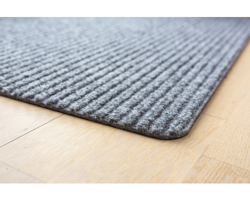 Graue Fußmatte mit Rippenstruktur auf Holzboden