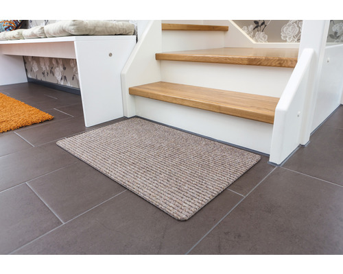 Fußmatte vor einer Treppe auf Fliesenboden