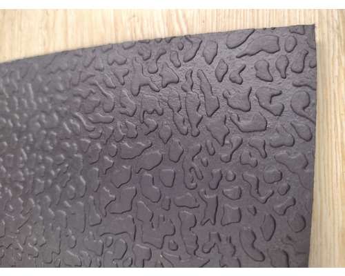 Tapis en caoutchouc noir avec motif irrégulier.