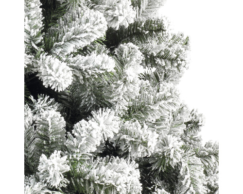 Detailaufnahme eines künstlichen Weihnachtsbaums mit beschneiten Zweigen.