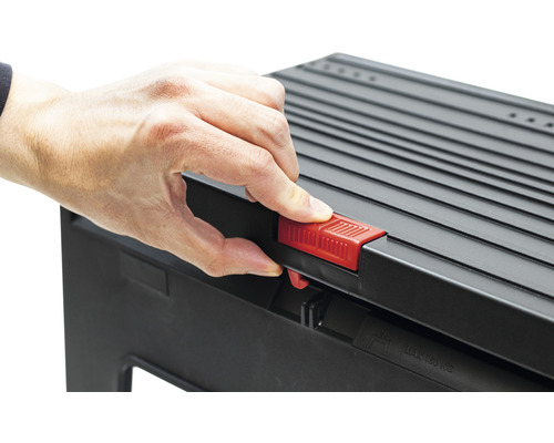 Hand betätigt roten Verschluss einer schwarzen Trittstufe