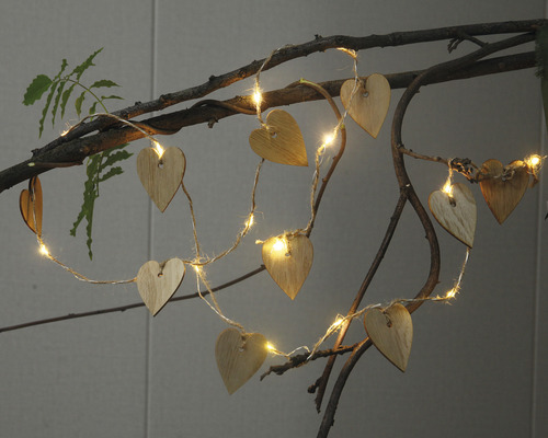 Lichterkette mit Holzherzen auf einem Ast