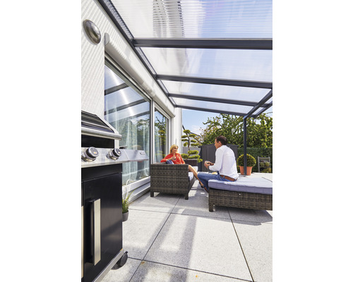 Überdachte Terrasse mit Grill und Sitzgelegenheiten im Garten