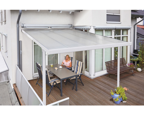 Terrasse avec auvent, table et chaises sur un plancher en bois