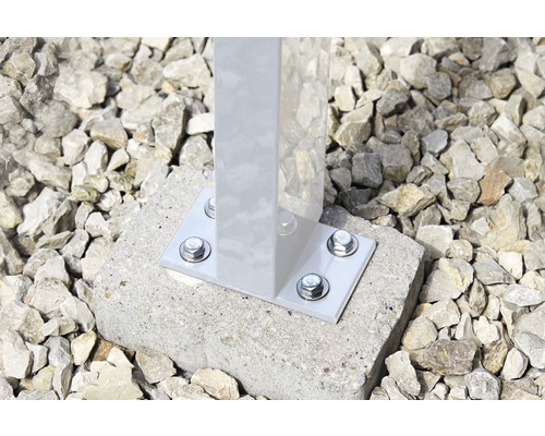 Detailansicht eines befestigten Pfostens mit Montageplatte und Schrauben auf einem Betonfundament