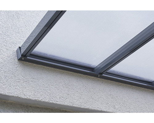 Nahaufnahme einer Terrassenüberdachung mit Polycarbonatplatten und Aluminiumrahmen an einer Hauswand