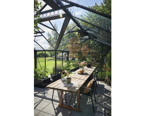 Serre avec table à manger, chaises et suspensions en rotin