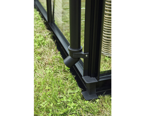 Gros plan d''un système de drainage de serre noir à la base sur de l''herbe