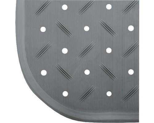 Détail d''un tapis de douche avec trous et surface côtelée