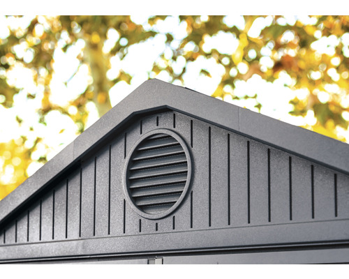 Detailansicht eines Gartenhauses mit rundem Lüftungsgitter im Giebel.