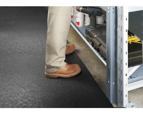 Scène avec une personne debout devant une étagère sur un tapis de sol