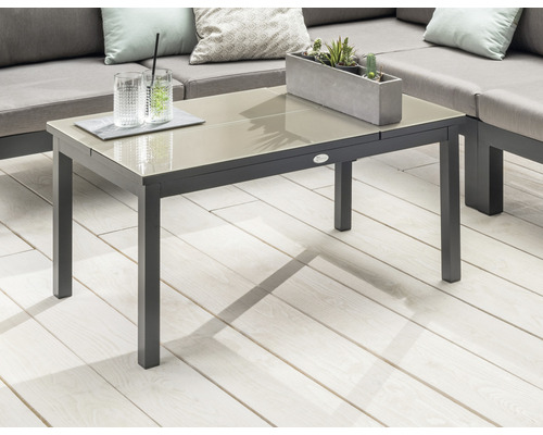 Table de jardin avec plateau en verre, boissons et décoration sur une terrasse