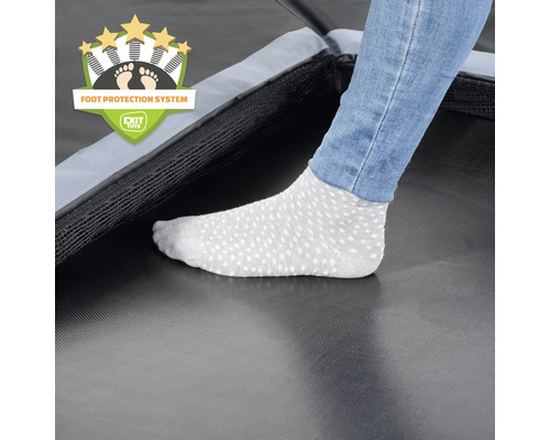 Detailaufnahme eines Trampolins mit Fußschutzsystem und einer Person mit Socken.