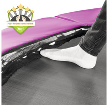 Gros plan d''un trampoline avec système de protection des pieds et d''une personne qui se coince le pied entre le cadre et la toile de saut