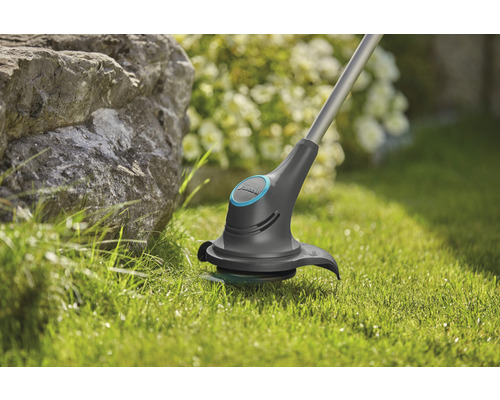 Rasentrimmer im Einsatz auf Rasenfläche im Garten.