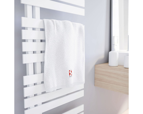 Weißes Handtuch auf einem weißen Handtuchwärmer im Badezimmer.