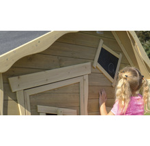 Gros plan d''une cabane de jeu en bois pour enfants avec un tableau noir sur lequel une fillette dessine.