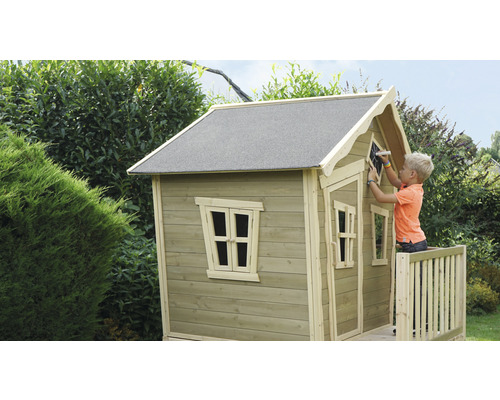 Kind malt auf ein Holzspielhaus im Garten