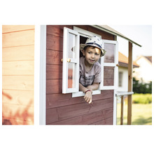 Un enfant regarde par la fenêtre d''une cabane de jeu