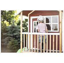 Enfant sur la véranda d''une cabane de jeu dans le jardin.