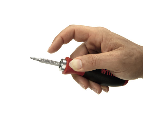 Main tenant un tournevis avec embouts interchangeables