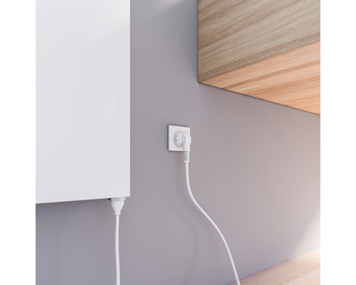 Detailaufnahme eines an der Wand montierten Heizkörpers mit Stecker in der Steckdose