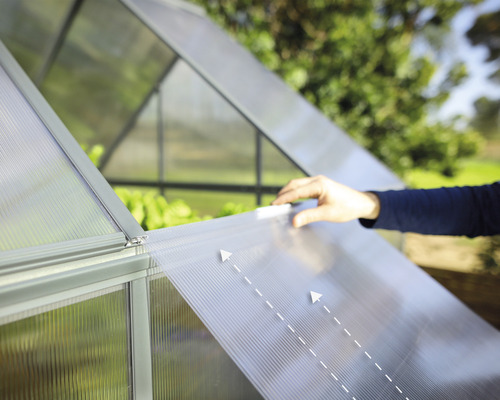 Detailansicht eines Gewächshauses mit einer Person, die eine durchsichtige Platte verschiebt