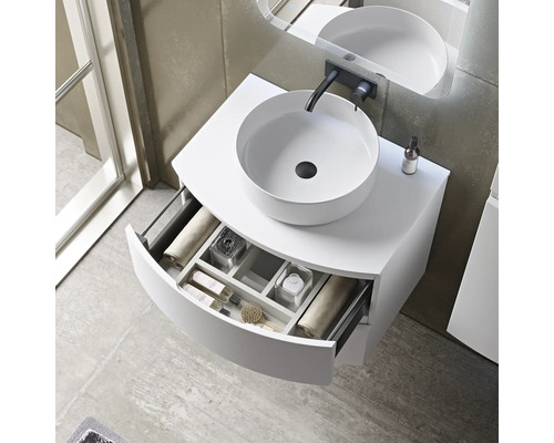 Meuble-lavabo avec vasque à poser ronde et tiroir ouvert pour les accessoires de salle de bain.
