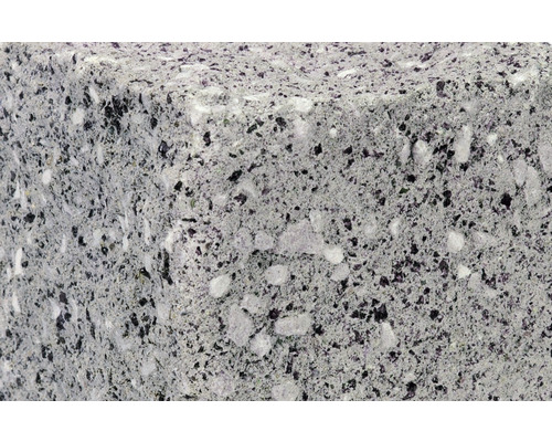 Nahaufnahme eines Betonpflastersteins mit gesprenkelter Oberfläche