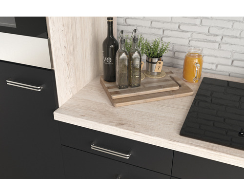 Coin cuisine avec plan de travail aspect bois, bouteilles, planches à découper et plaque de cuisson