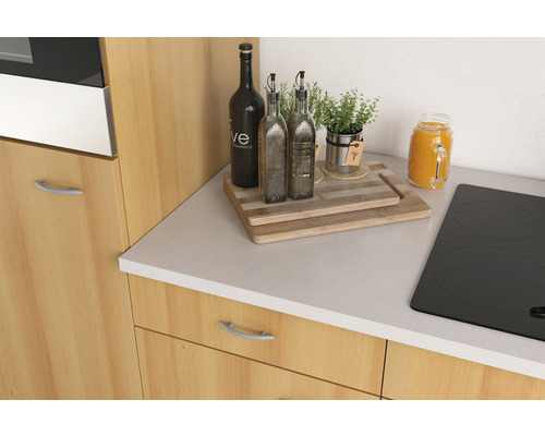 Coin cuisine avec plaque de cuisson, plan de travail, planches à découper et ustensiles de cuisine