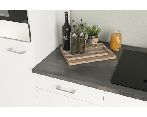 Küchenstillleben mit Schneidebrettern, Ölflaschen, Kräutern und Kochfeld auf einer Arbeitsplatte