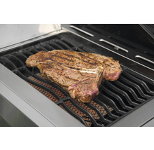 Un steak T-bone sur une grille de barbecue