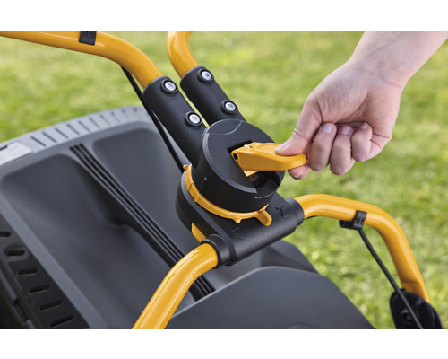 Detailaufnahme der Bedienelemente eines Rasenmähers mit Hand am gelben Hebel