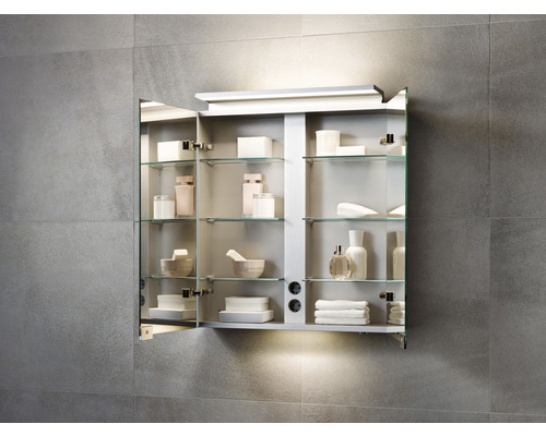 Armoire de toilette ouverte avec étagères en verre et articles de salle de bains sur un mur carrelé