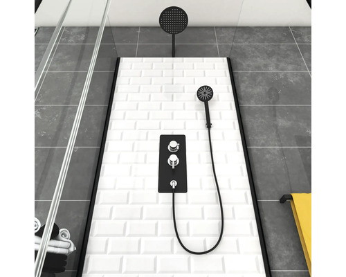 Douche moderne avec pomme de tête, douchette à main et robinet thermostatique devant des carreaux de métro blancs