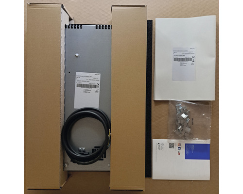 Plaque à induction avec accessoires dans un emballage en carton.