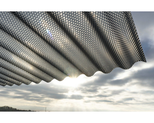 Panneau de construction ondulé à motif losanges sur fond de ciel nuageux