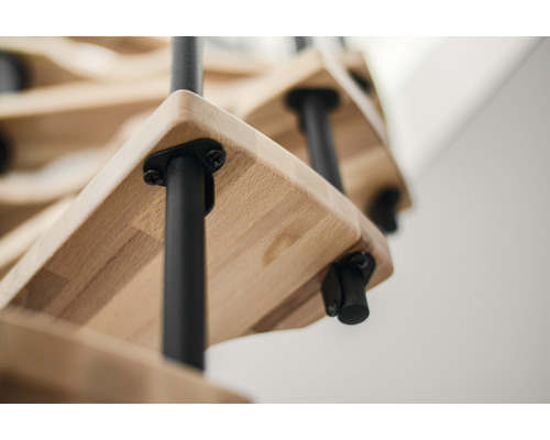 Detailaufnahme einer Holztreppe mit schwarzen Geländerstäben