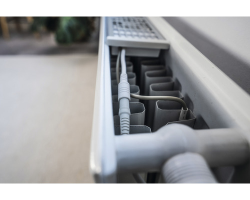 Nahaufnahme eines Heizkörpers mit Kabelanschluss