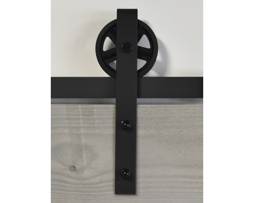 Ferrure de porte coulissante avec rail noir et suspension à roulettes sur une porte en bois