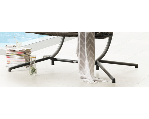 Detailansicht von Gartenmöbeln mit Zeitschriftenstapel, Getränk und Tuch