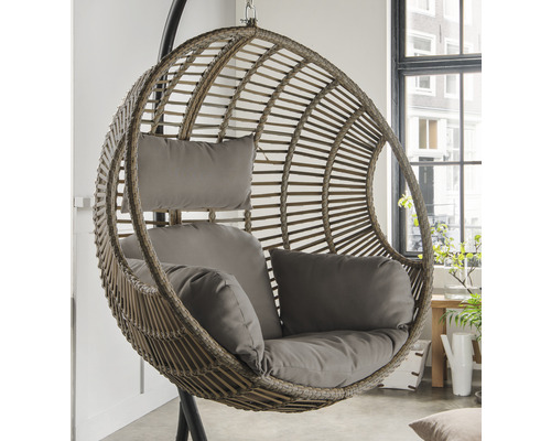 Hängesessel aus Rattan mit Kissen an einem dunklen Metallgestell