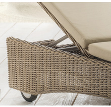Detail einer Gartenliege mit Rattanstruktur und Rädern