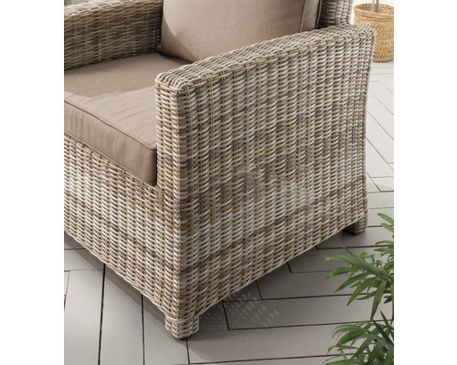 Gros plan d''un fauteuil en rotin avec coussins