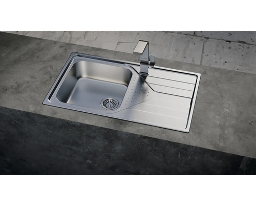 Edelstahlspüle mit Abtropffläche und Armatur auf einer Arbeitsplatte