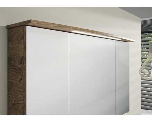 Detailansicht eines Badezimmerschranks mit Holzoberfläche und weißen Fronten