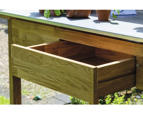 Gros plan sur une table de jardin en bois avec un tiroir ouvert